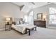 Bright bedroom with a tufted headboard, bench, large windows and neutral colors at 389 Mill Creek Ne Bnd, Atlanta, GA 30307