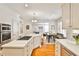Open-concept kitchen with white cabinetry, quartz countertops, stainless steel appliances and hardwood floors at 389 Mill Creek Ne Bnd, Atlanta, GA 30307