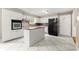 Kitchen featuring white cabinets, black appliances, island, and tile flooring at 6033 Morrow Cv, Morrow, GA 30260