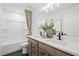 Modern bathroom with double sinks, wood cabinets, and a bathtub with shower at 6106 Marigold Way, Atlanta, GA 30349