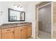 Bathroom showcases a granite countertop, wood cabinets, an over-sized mirror, and a glass-door shower with stone-look tile at 1410 Eastland Rd Se Rd, Atlanta, GA 30316
