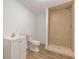 Bathroom featuring a vanity sink, toilet, and shower with neutral tiling and vinyl flooring at 1410 Eastland Rd Se Rd, Atlanta, GA 30316