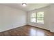 This bedroom features hardwood floors and a window overlooking a lush green outdoor space at 1410 Eastland Rd Se Rd, Atlanta, GA 30316