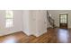 Hardwood floors flow from the living room, showcasing the entryway and staircase with natural light from the adjacent window at 1410 Eastland Rd Se Rd, Atlanta, GA 30316