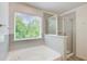 Bright bathroom featuring a soaking tub and gray tiled shower at 550 Constellation Overlook Sw, Atlanta, GA 30331