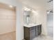 Double sink bathroom vanity featuring dark wood cabinets and a walk-in closet nearby at 550 Constellation Overlook Sw, Atlanta, GA 30331
