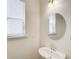 Powder room features pedestal sink, oval mirror, and window for natural light at 550 Constellation Overlook Sw, Atlanta, GA 30331