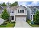 Charming two-story home with gray siding, stone accents, a well-manicured lawn, and a two car garage at 550 Constellation Overlook Sw, Atlanta, GA 30331