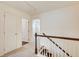 Upstairs hallway featuring carpet, white doors, and wood and white railing at 550 Constellation Overlook Sw, Atlanta, GA 30331