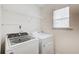 Well-lit laundry room featuring a white washer and dryer set and wire shelving at 550 Constellation Overlook Sw, Atlanta, GA 30331