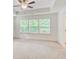 Large bedroom with tray ceiling, fan, three windows, and neutral colored carpet at 550 Constellation Overlook Sw, Atlanta, GA 30331