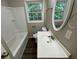 Bright bathroom with a modern vanity, tub, and a large window at 6106 Oak Hill Sw Dr, Austell, GA 30168