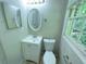 Bathroom featuring a toilet, mirror, single sink vanity, and double-hung window at 6106 Oak Hill Sw Dr, Austell, GA 30168