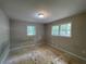 Bedroom featuring bare plywood flooring, standard ceiling light, and double-hung windows at 6106 Oak Hill Sw Dr, Austell, GA 30168