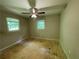 Bedroom featuring bare plywood flooring, standard ceiling fan and light, and double-hung windows at 6106 Oak Hill Sw Dr, Austell, GA 30168