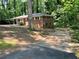 View of the home's exterior surrounded by a lawn and mature trees; features brick, siding, and covered entryway at 6106 Oak Hill Sw Dr, Austell, GA 30168