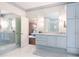 Bathroom with double vanity, cabinets, large mirrors, and a doorway to the Primary bedroom at 70 Finch Forest Trl, Atlanta, GA 30327