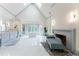 A vaulted bathroom with a fireplace, marble flooring, and a garden tub below large windows at 70 Finch Forest Trl, Atlanta, GA 30327