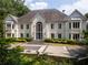 Elegant two-story home with a grand entrance, manicured landscaping, and a circular driveway at 70 Finch Forest Trl, Atlanta, GA 30327