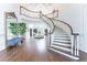 Grand foyer with curved staircase, chandelier, high ceilings, hardwood floors, and decorative mirror at 70 Finch Forest Trl, Atlanta, GA 30327