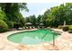 Lush backyard pool with patio, lounge chairs, mature trees, and pristine landscaping at 70 Finch Forest Trl, Atlanta, GA 30327
