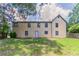 View of the rear exterior and backyard with trees, lawn, and wood fencing at 10 Briarcliff Pl, Stockbridge, GA 30281