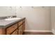 Bathroom vanity featuring wood cabinets, dark countertops and a clean white sink at 10 Briarcliff Pl, Stockbridge, GA 30281
