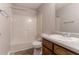 A clean and bright bathroom featuring a white shower-tub combo, toilet and single sink with wooden cabinet at 10 Briarcliff Pl, Stockbridge, GA 30281