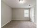 A carpeted bedroom with neutral walls, a window and white door offers a serene and comfortable living space at 10 Briarcliff Pl, Stockbridge, GA 30281