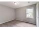 A carpeted bedroom features natural light from a window and neutral colored walls at 10 Briarcliff Pl, Stockbridge, GA 30281