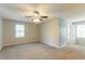 Spacious bedroom with neutral carpet, ceiling fan, and natural light from two windows at 10 Briarcliff Pl, Stockbridge, GA 30281