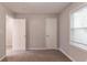 A carpeted bedroom features natural light from a window, neutral walls and two closet doors at 10 Briarcliff Pl, Stockbridge, GA 30281