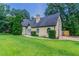 Cozy home featuring mature trees, a tidy lawn, a circular walkway, and a side yard gate at 10 Briarcliff Pl, Stockbridge, GA 30281