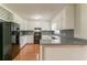 Well-lit kitchen features classic white cabinets, black appliances, and hard wood flooring at 10 Briarcliff Pl, Stockbridge, GA 30281