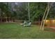 Private backyard featuring mature trees, string lights, and lounge chairs on well-maintained grass at 3357 Pretty Branch Se Dr, Smyrna, GA 30080