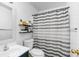 Bathroom with striped shower curtain, a sink and shelves at 5357 Beaver Br, Norcross, GA 30071