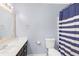 Bathroom with blue and white shower curtain, toilet, mirror, and sink at 5357 Beaver Br, Norcross, GA 30071