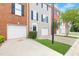 View of townhome exteriors showing garages, blue shutters, brick and gray siding, and manicured lawns at 5357 Beaver Br, Norcross, GA 30071