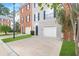 Townhome exteriors featuring brick and gray siding, with one car garages, blue shutters and landscaped lawns at 5357 Beaver Br, Norcross, GA 30071