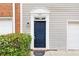 Close-up of a townhome's front door with a blue door, white trim, and manicured green shrubs at 5357 Beaver Br, Norcross, GA 30071