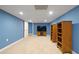 Finished basement with blue walls, light carpeting, entertainment area, and open layout at 212 Warrenton Dr, Douglasville, GA 30134