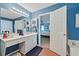 Bright bathroom features blue walls, white vanity with sink, and a view into the bedroom at 212 Warrenton Dr, Douglasville, GA 30134