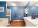 Bright blue bathroom showcasing a walk-in shower, soaking tub, and modern vanity at 212 Warrenton Dr, Douglasville, GA 30134