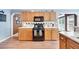 Well-lit kitchen with wood cabinets, black appliances, and laminate floors at 212 Warrenton Dr, Douglasville, GA 30134