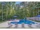 A luxurious swimming pool with a slide, surrounded by seating and mature trees, perfect for summer fun at 212 Warrenton Dr, Douglasville, GA 30134