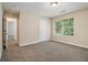 Bright bedroom with neutral walls, plush carpet, and a large window overlooking the backyard at 2120 Glenwood Downs Dr, Decatur, GA 30035