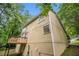 Exterior view of a multi-story home surrounded by mature trees, a wooden deck, and a well kept lawn at 2120 Glenwood Downs Dr, Decatur, GA 30035