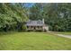 Inviting single-Gathering home with a green lawn, mature trees, and an attached garage at 2120 Glenwood Downs Dr, Decatur, GA 30035