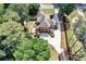 Expansive aerial view of a brick house, mature trees, and a private backyard with a deck at 5121 Hunters Hill Sw Cv, Lilburn, GA 30047