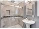 Modern bathroom featuring a walk-in glass shower, pedestal sink, and neutral tile at 5121 Hunters Hill Sw Cv, Lilburn, GA 30047